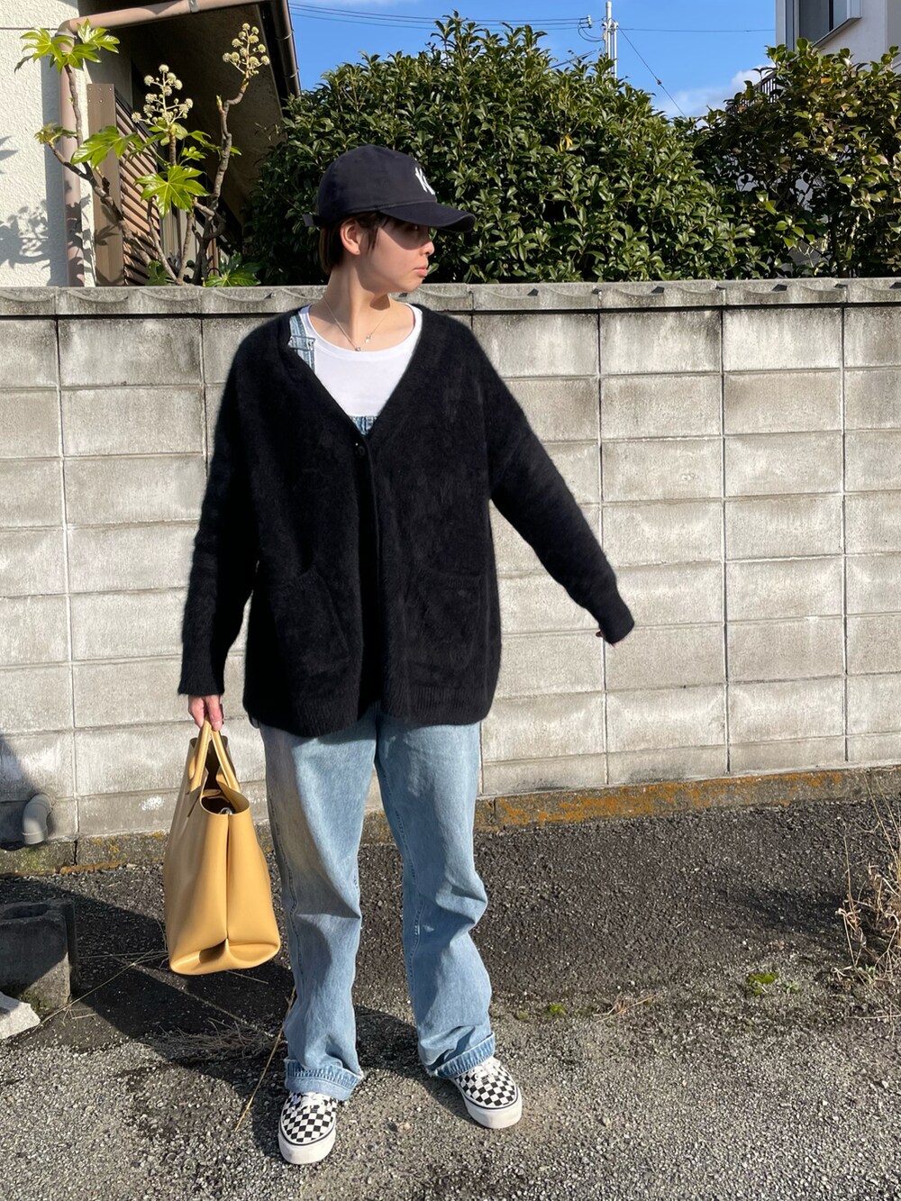 ブルー系のカーディガン/ボレロ、ブルー系のサロペット/オーバーオール、イエロー系のハンドバッグを着用したレディースの冬コーディネートの2枚目の写真