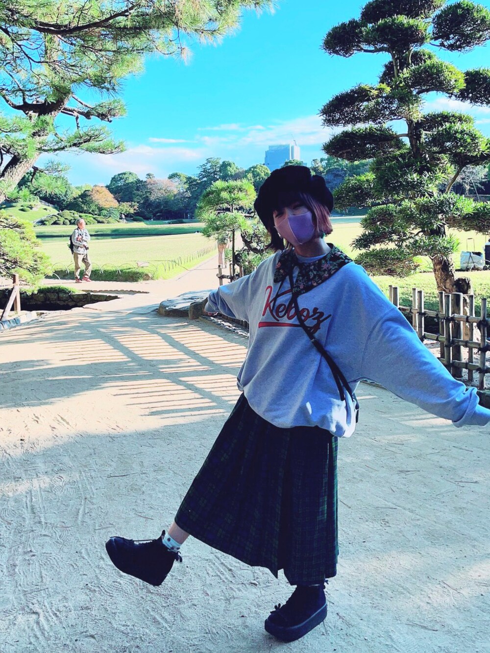 グレー系のスウェット、ブラック系のショルダーバッグ、グリーン系のスカートを着用したレディースの秋コーディネートの5枚目の写真