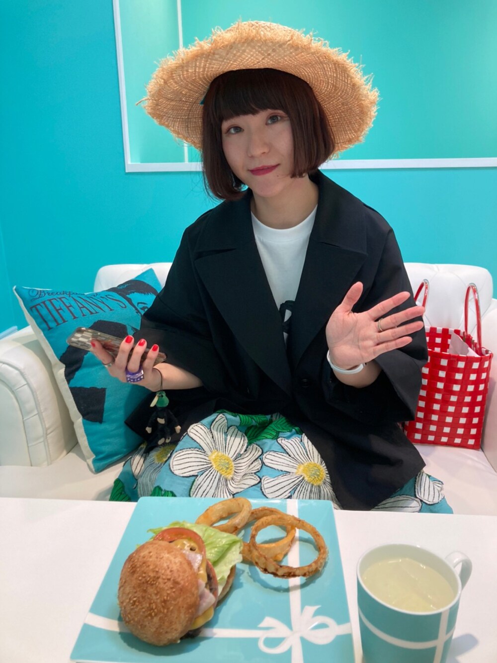 ブラック系のチェスターコート、ホワイト系のTシャツ/カットソー、ブルー系のスカートを着用したレディースの夏コーディネートの2枚目の写真