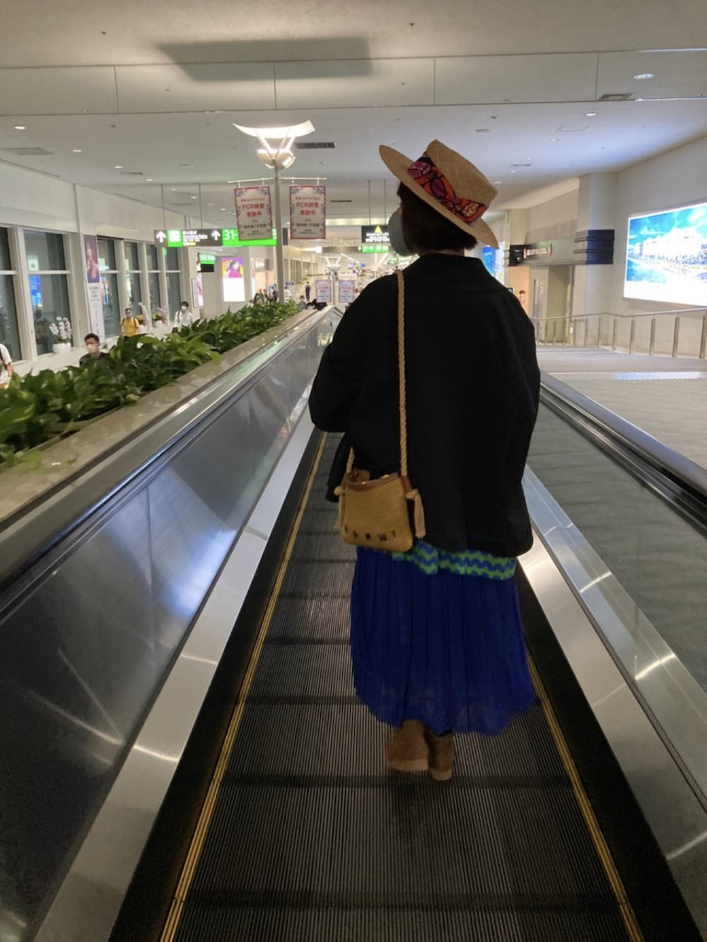 ベージュ系のボディバッグ/ウエストポーチ、ブラック系のチェスターコート、グリーン系のTシャツ/カットソーを着用したレディースの冬コーディネートの5枚目の写真