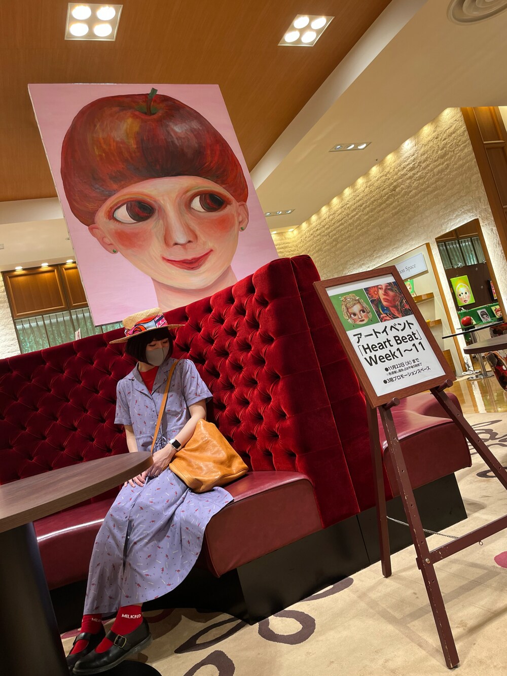 レッド系のニット/セーター、パープル系のワンピース、ベージュ系のショルダーバッグを着用したレディースの秋コーディネートの2枚目の写真