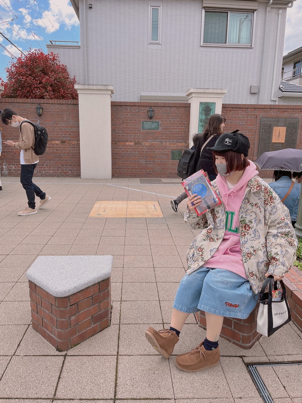 ベージュ系のブルゾン、ピンク系のパーカー、ホワイト系のトートバッグを着用したレディースの春コーディネートの2枚目の写真