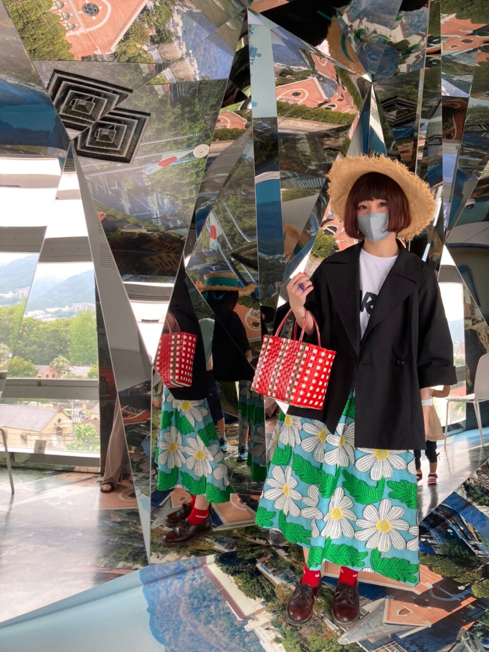 ブラック系のチェスターコート、ホワイト系のTシャツ/カットソー、ブルー系のスカートを着用したレディースの夏コーディネートの4枚目の写真