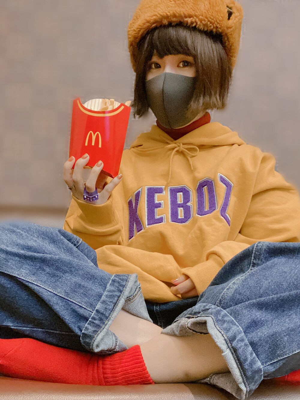 イエロー系のパーカー、ブルー系のデニムパンツ、グリーン系のスニーカーを着用したレディースの冬コーディネートの2枚目の写真