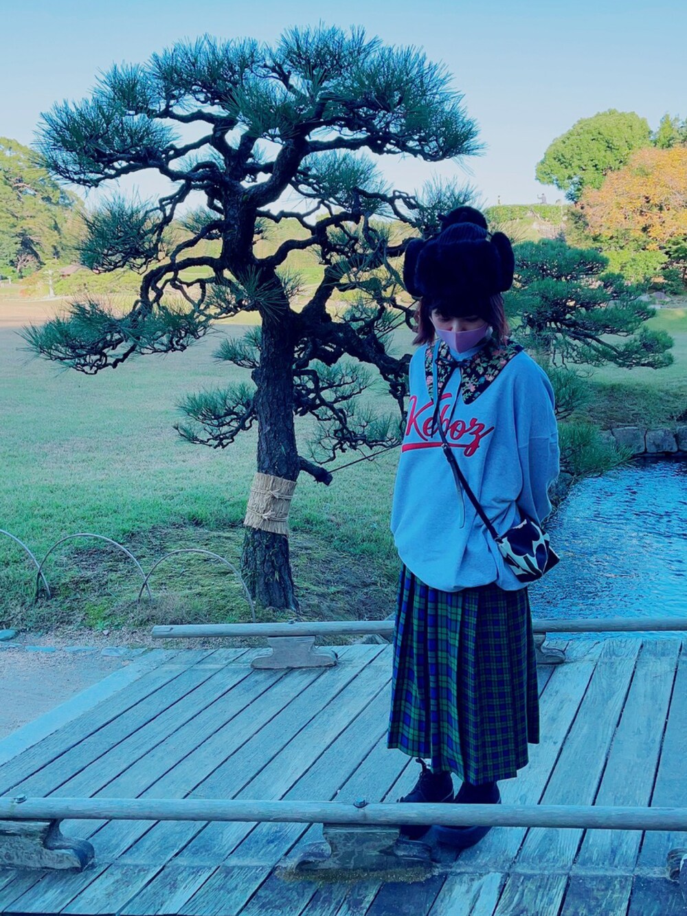 グレー系のスウェット、ブラック系のショルダーバッグ、グリーン系のスカートを着用したレディースの秋コーディネートの3枚目の写真