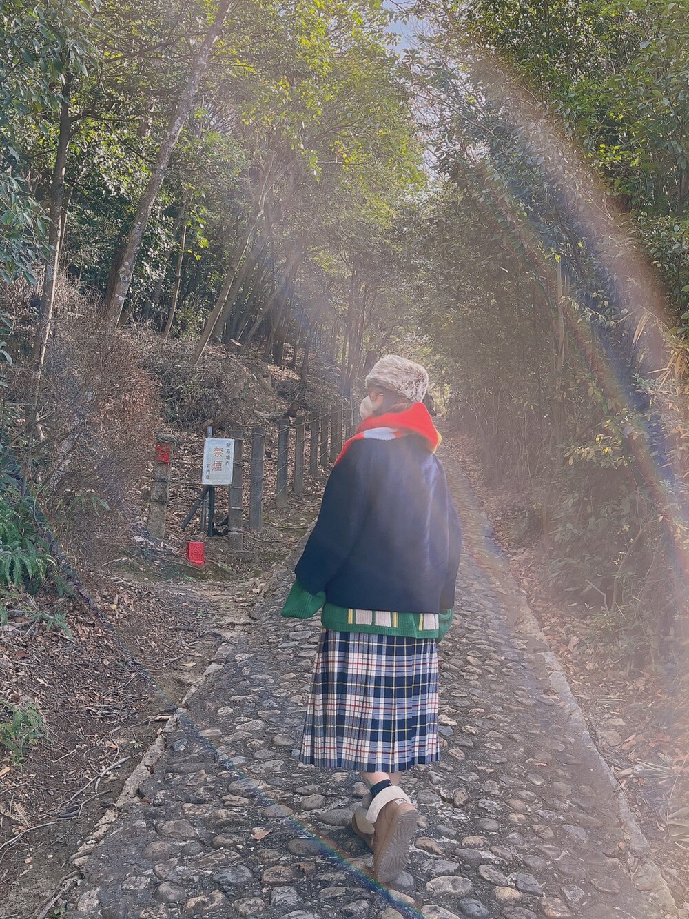 ブルー系のノーカラージャケット、グリーン系のカーディガン/ボレロ、ブルー系のスカートを着用したレディースの冬コーディネートの2枚目の写真