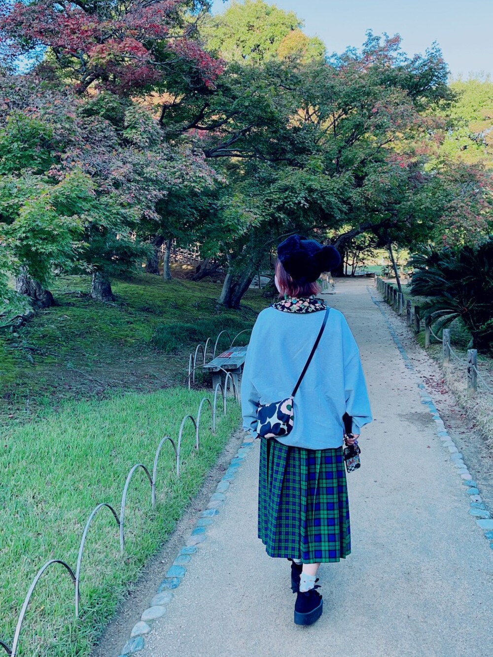 グレー系のスウェット、ブラック系のショルダーバッグ、グリーン系のスカートを着用したレディースの秋コーディネートの2枚目の写真