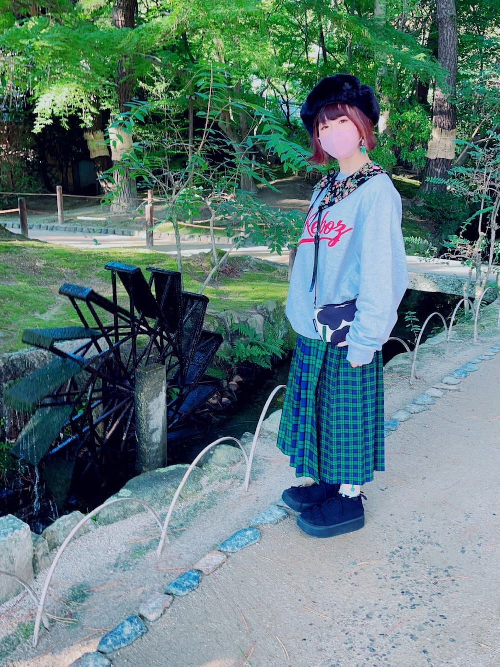 グレー系のスウェット、ブラック系のショルダーバッグ、グリーン系のスカートを着用したレディースの秋コーディネートの4枚目の写真