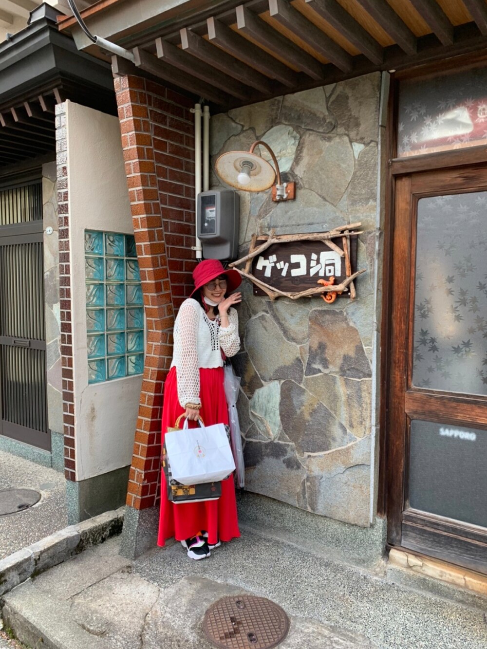 レッド系のスカート、レッド系のハットを着用したレディースの秋コーディネートの2枚目の写真