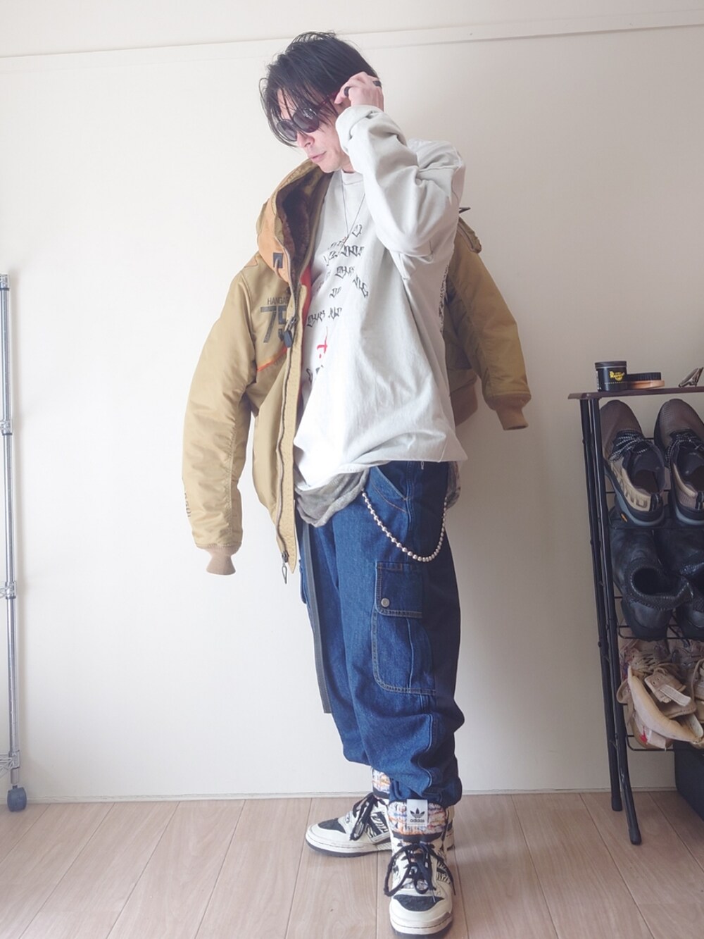 ブルー系のデニムパンツ、ホワイト系のスニーカー、イエロー系のMA-1を着用したメンズの春コーディネートの5枚目の写真