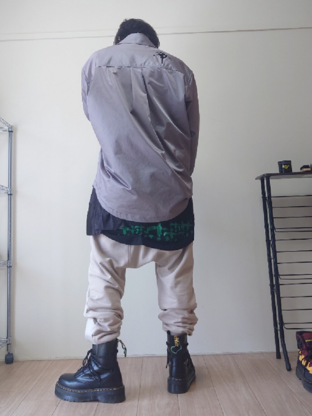 ベージュ系のその他パンツ、ブラック系のブーツ、ブラック系のTシャツ/カットソーを着用したメンズの春コーディネートの2枚目の写真