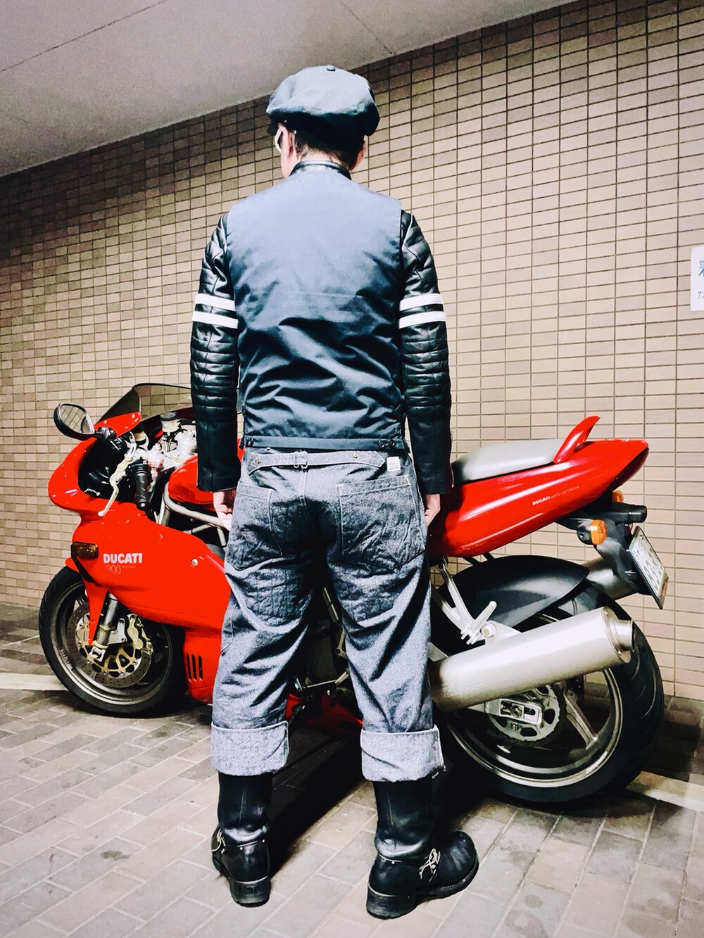 ブラック系のライダースジャケット、ブラック系のダウンベスト、グレー系のチノパンツを着用したメンズの冬コーディネートの5枚目の写真