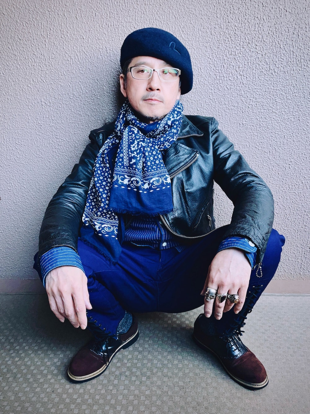 ブラック系のライダースジャケット、ブルー系のチノパンツ、ブラウン系のドレスシューズを着用したメンズの冬コーディネートの3枚目の写真