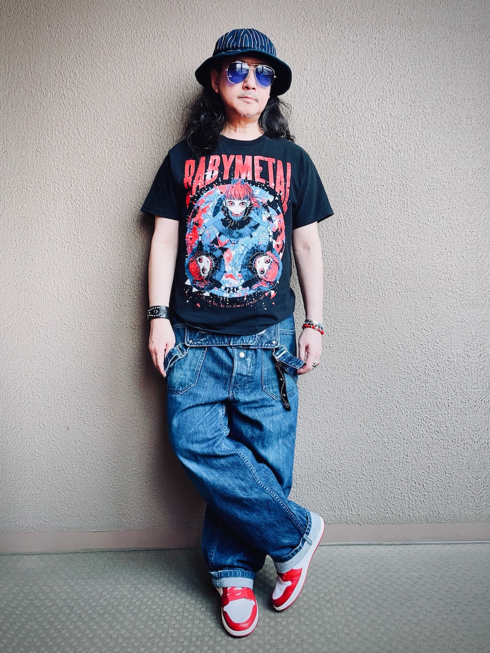 ブラック系のTシャツ/カットソー、ブルー系のサロペット/オーバーオール、レッド系のスニーカーを着用したメンズの夏コーディネートの2枚目の写真