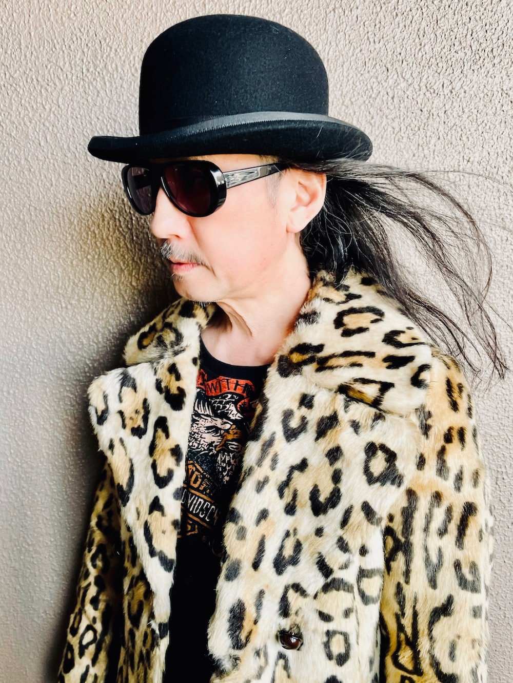 イエロー系のピーコート、ブラック系のデニムパンツ、ブラック系のブーツを着用したメンズの春コーディネートの5枚目の写真