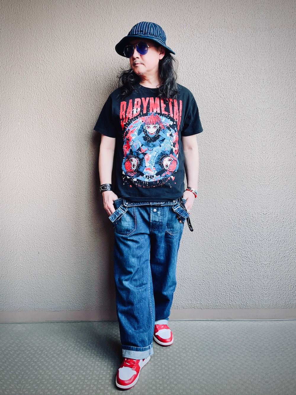 ブラック系のTシャツ/カットソー、ブルー系のサロペット/オーバーオール、レッド系のスニーカーを着用したメンズの夏コーディネートの5枚目の写真