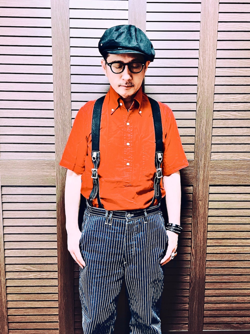 レッド系のシャツ/ブラウス、ブルー系のデニムパンツ、ブラック系のブーツを着用したメンズの夏コーディネートの2枚目の写真