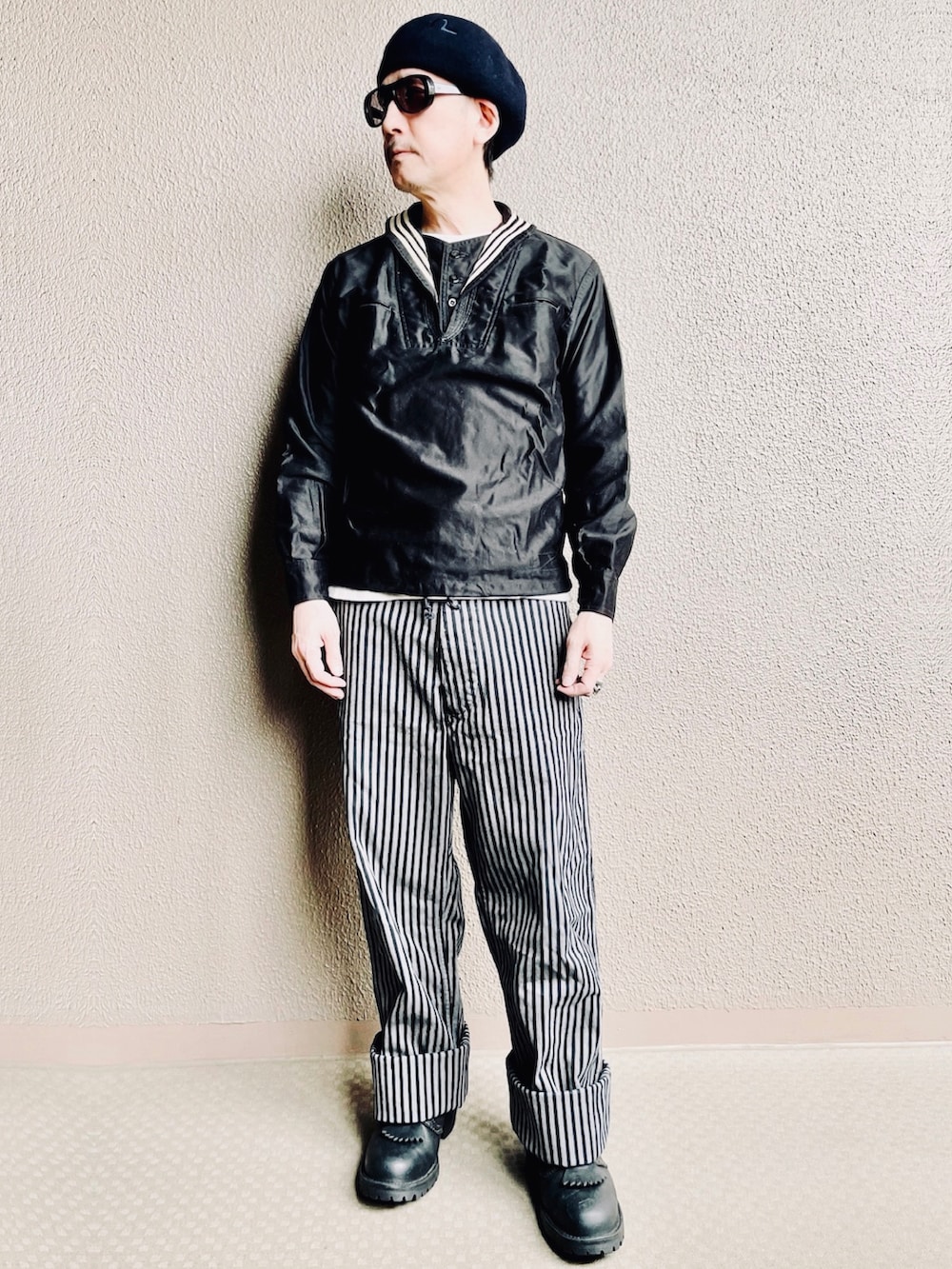 ブラック系のシャツ/ブラウス、グレー系のチノパンツ、ブラック系のブーツを着用したメンズの春コーディネートの2枚目の写真