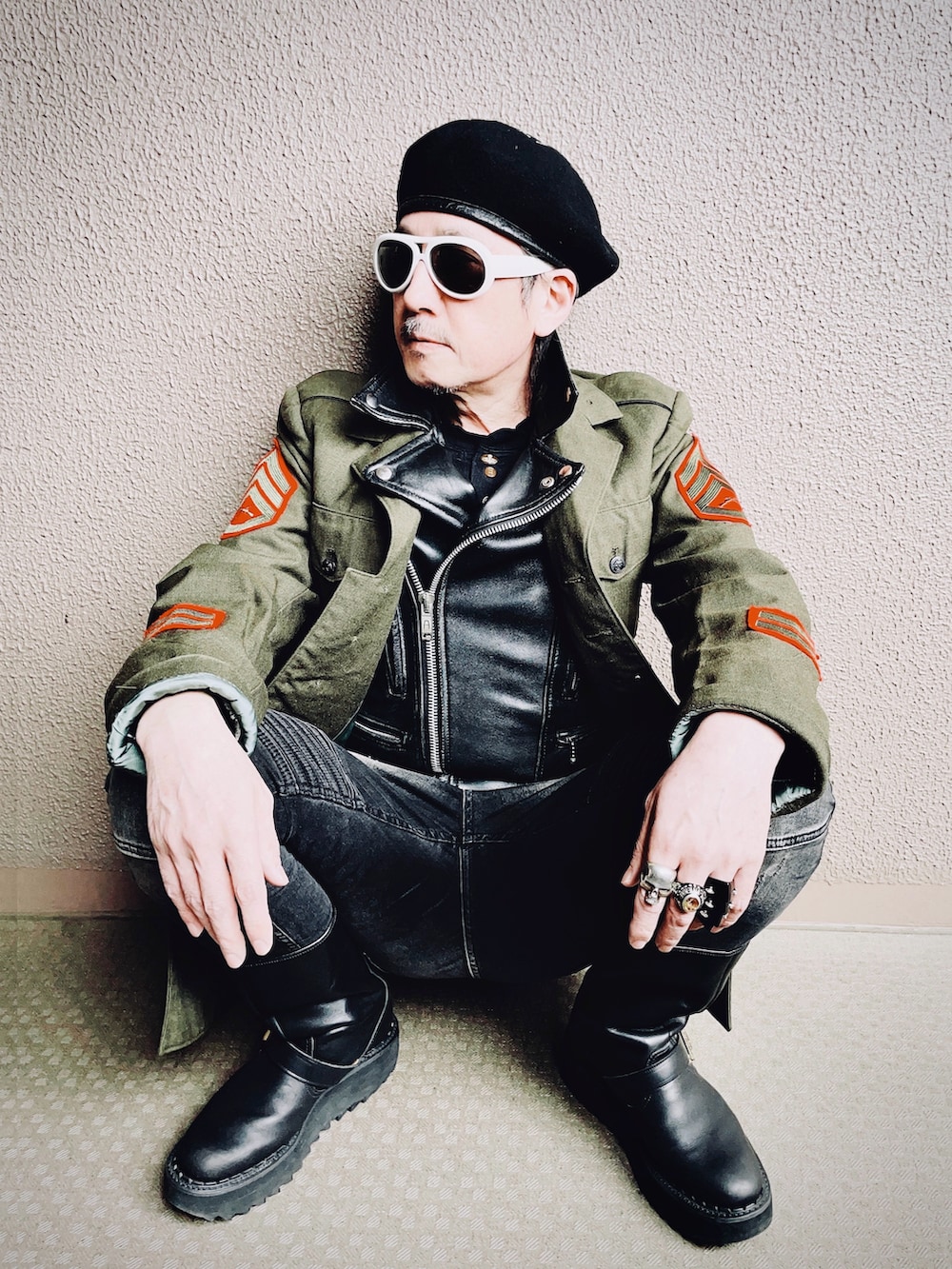 グリーン系のミリタリージャケット、ブラック系のライダースジャケット、ブラック系のデニムパンツを着用したメンズの冬コーディネートの3枚目の写真