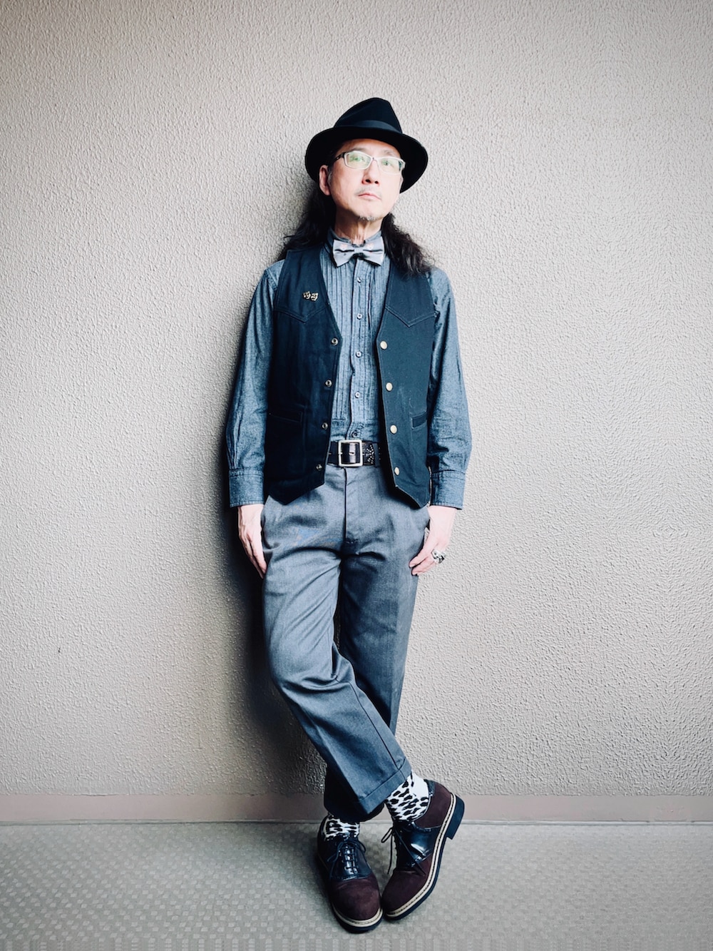 ブラック系のベスト、グレー系のスラックス、ブラウン系のドレスシューズを着用したメンズの秋コーディネートの2枚目の写真