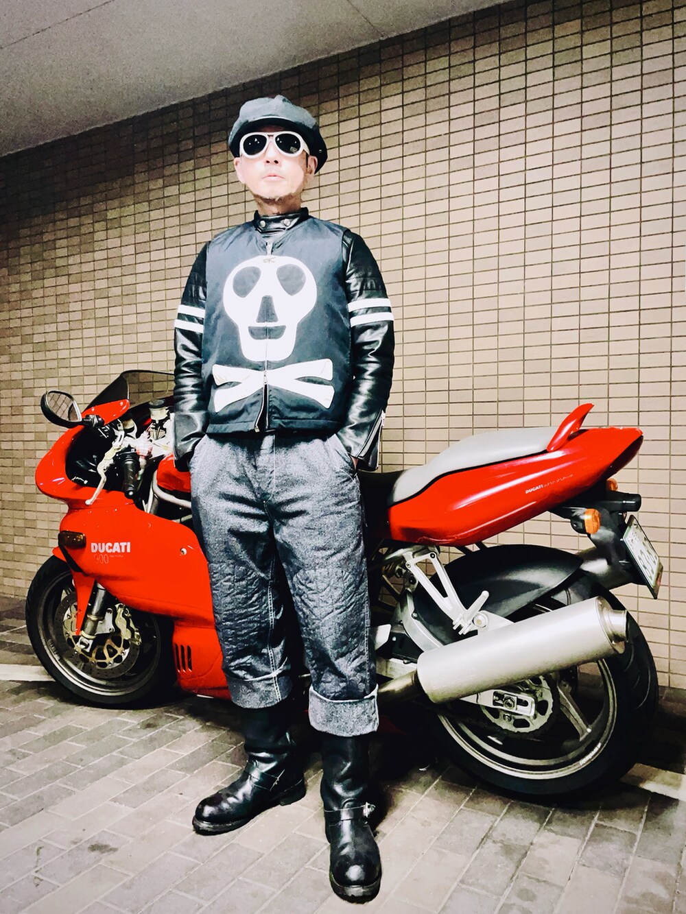 ブラック系のライダースジャケット、ブラック系のダウンベスト、グレー系のチノパンツを着用したメンズの冬コーディネートの2枚目の写真