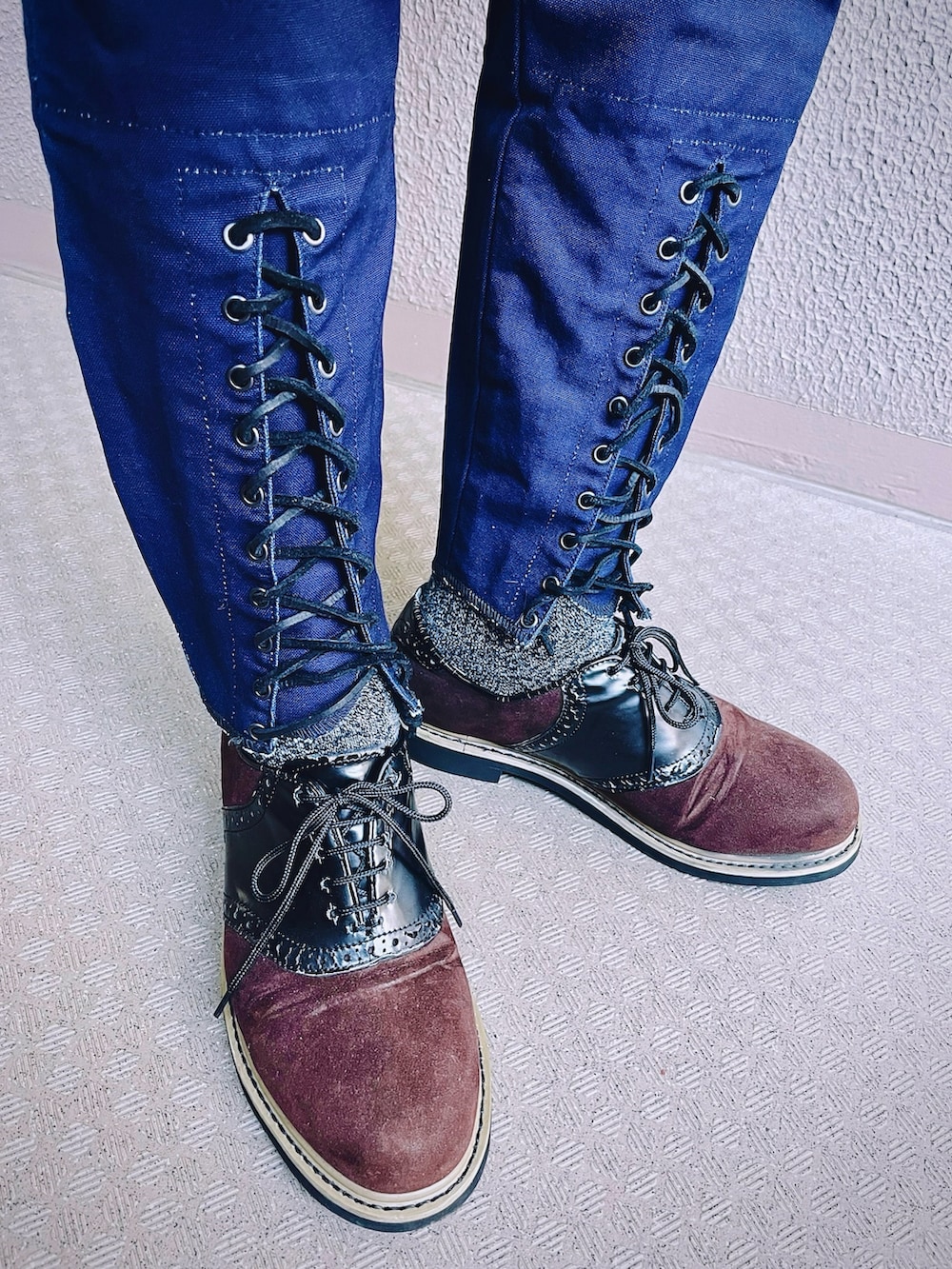 ブラック系のライダースジャケット、ブルー系のチノパンツ、ブラウン系のドレスシューズを着用したメンズの冬コーディネートの5枚目の写真