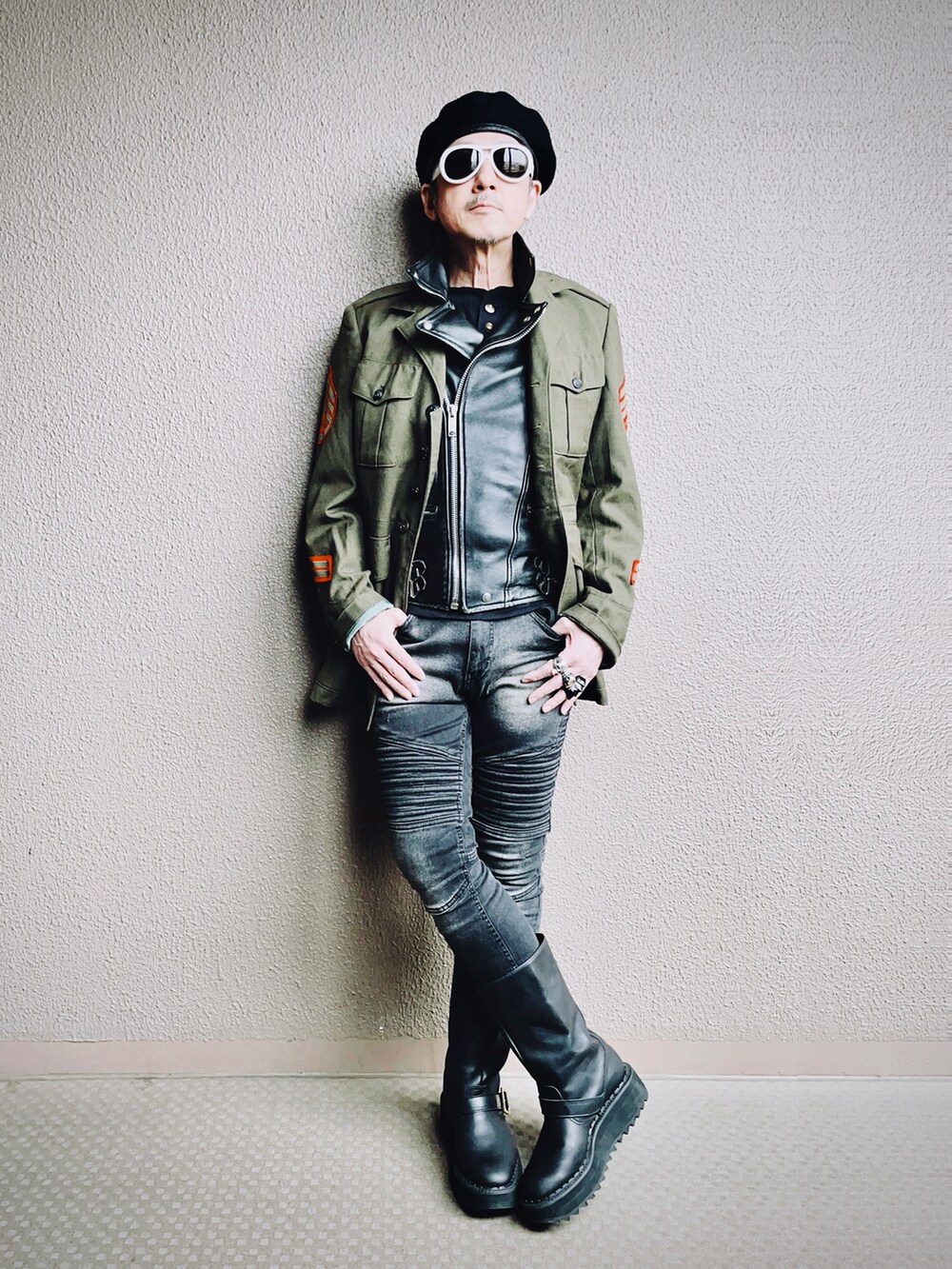グリーン系のミリタリージャケット、ブラック系のライダースジャケット、ブラック系のデニムパンツを着用したメンズの冬コーディネートの5枚目の写真