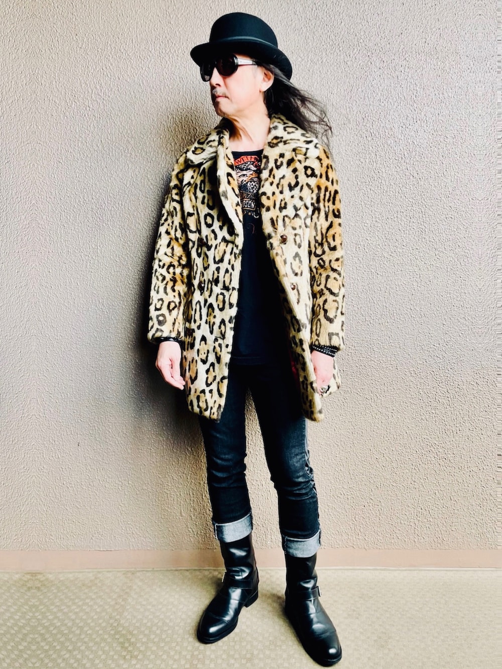 イエロー系のピーコート、ブラック系のデニムパンツ、ブラック系のブーツを着用したメンズの春コーディネートの4枚目の写真