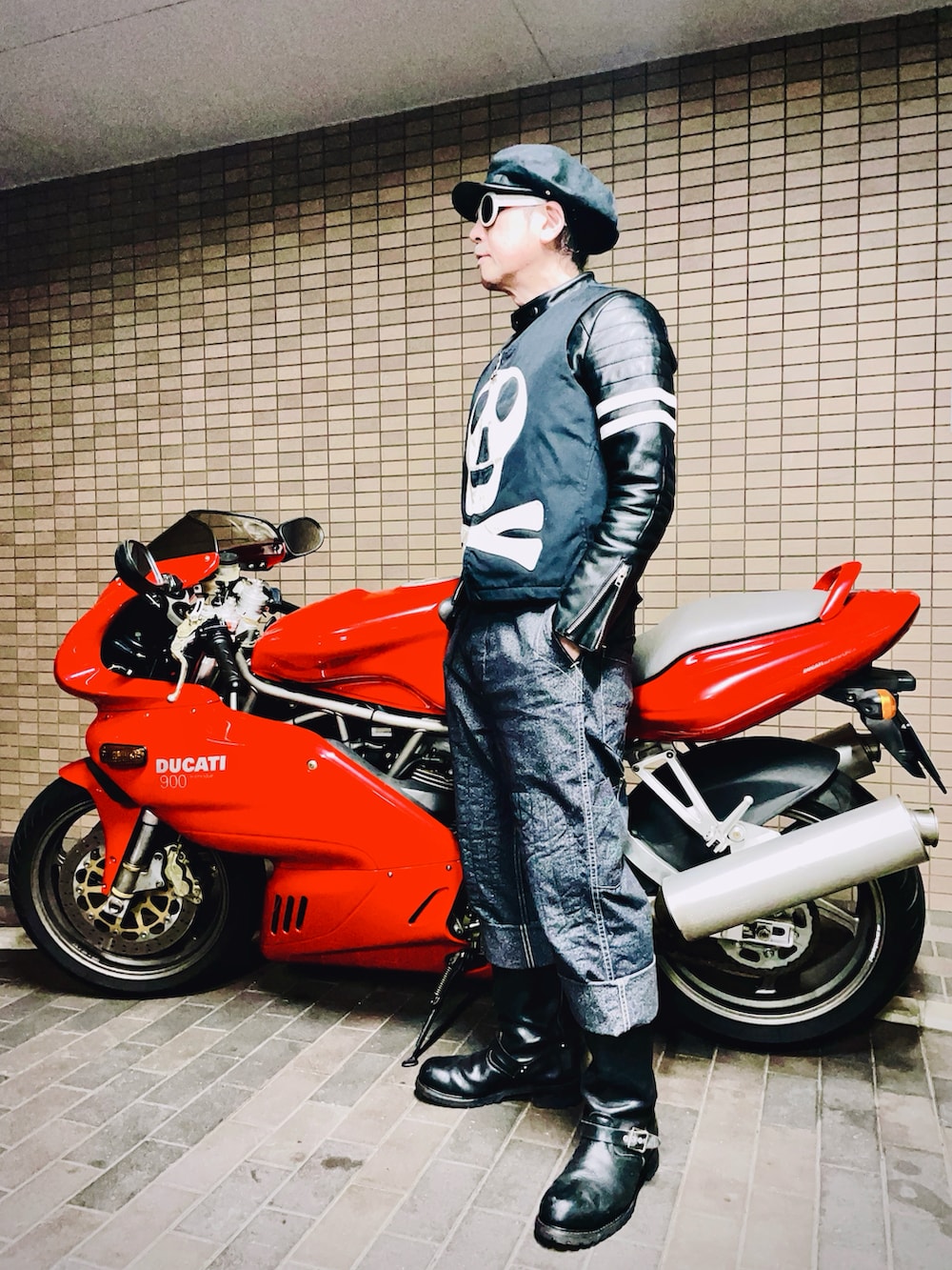 ブラック系のライダースジャケット、ブラック系のダウンベスト、グレー系のチノパンツを着用したメンズの冬コーディネートの3枚目の写真