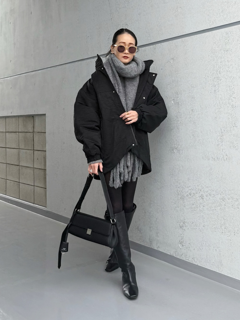 ブラック系のブルゾン、ブラック系のショルダーバッグを着用したレディースの冬コーディネートの4枚目の写真