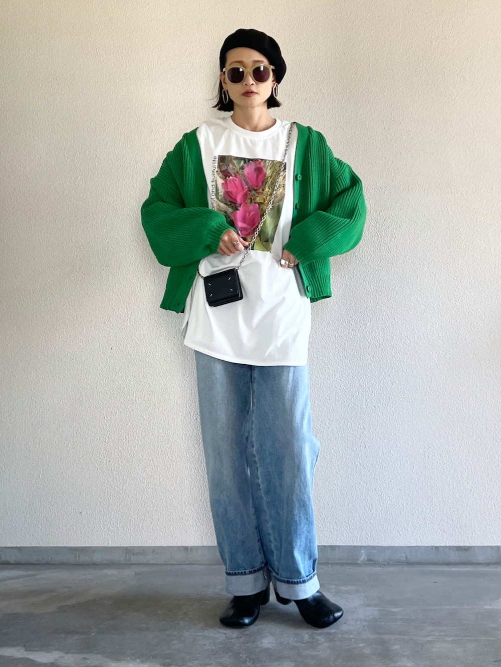 グリーン系のカーディガン/ボレロ、ホワイト系のTシャツ/カットソー、ブルー系のデニムパンツを着用したレディースの秋コーディネートの2枚目の写真