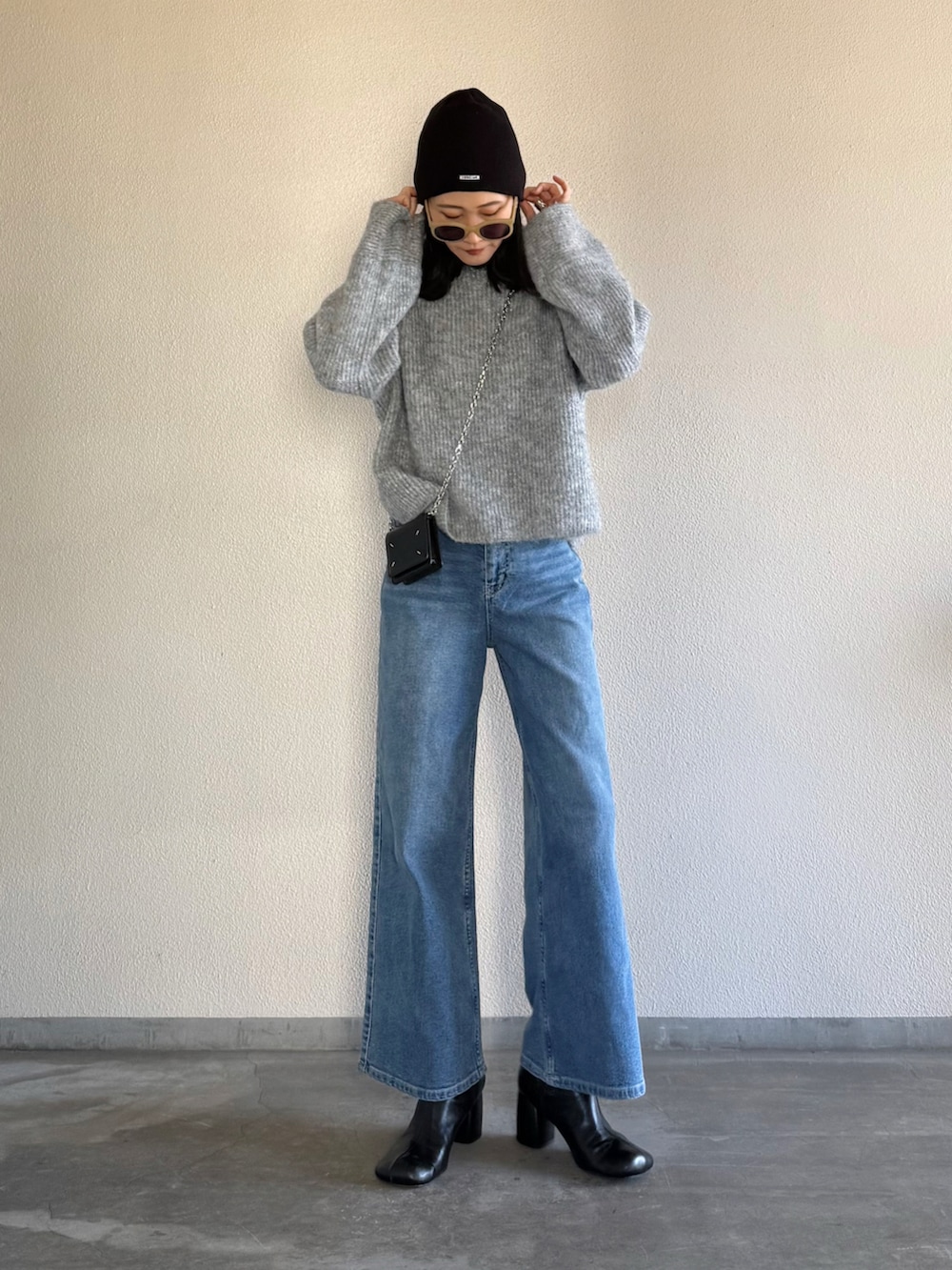 ブルー系のデニムパンツ、グレー系のニット/セーターを着用したレディースの冬コーディネートの5枚目の写真