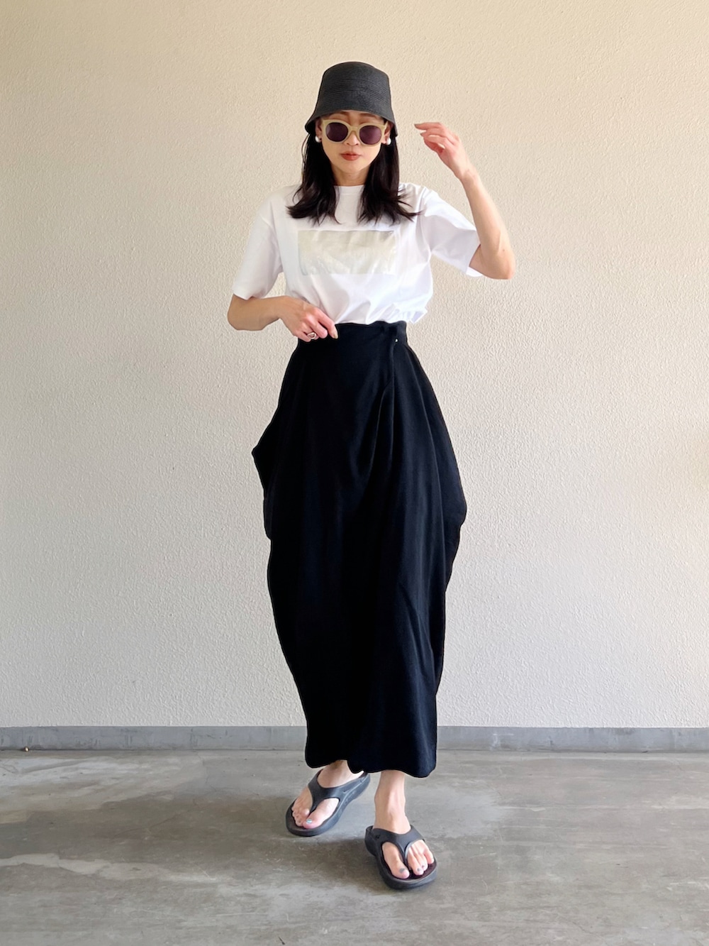 ホワイト系のTシャツ/カットソー、ブラック系のスカート、ブラック系のサンダルを着用したレディースの夏コーディネートの5枚目の写真