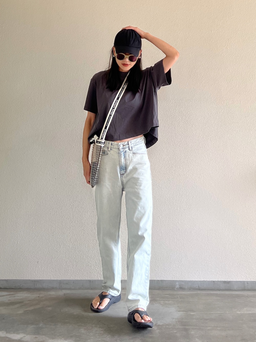 グレー系のTシャツ/カットソー、ブルー系のデニムパンツ、ブラック系のサンダルを着用したレディースの夏コーディネートの2枚目の写真