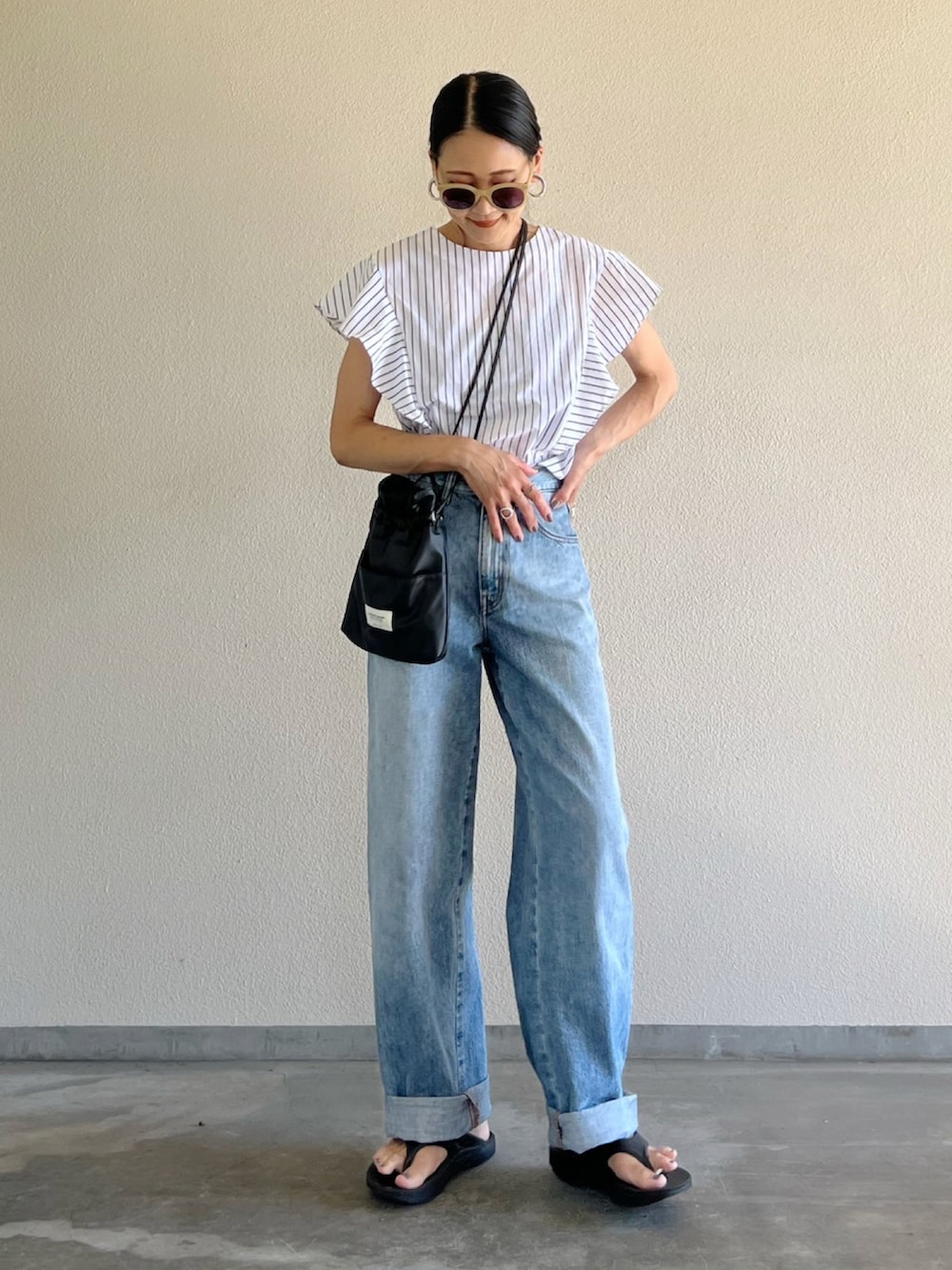 ホワイト系のシャツ/ブラウス、ブルー系のデニムパンツ、ブラック系のショルダーバッグを着用したレディースの夏コーディネートの3枚目の写真