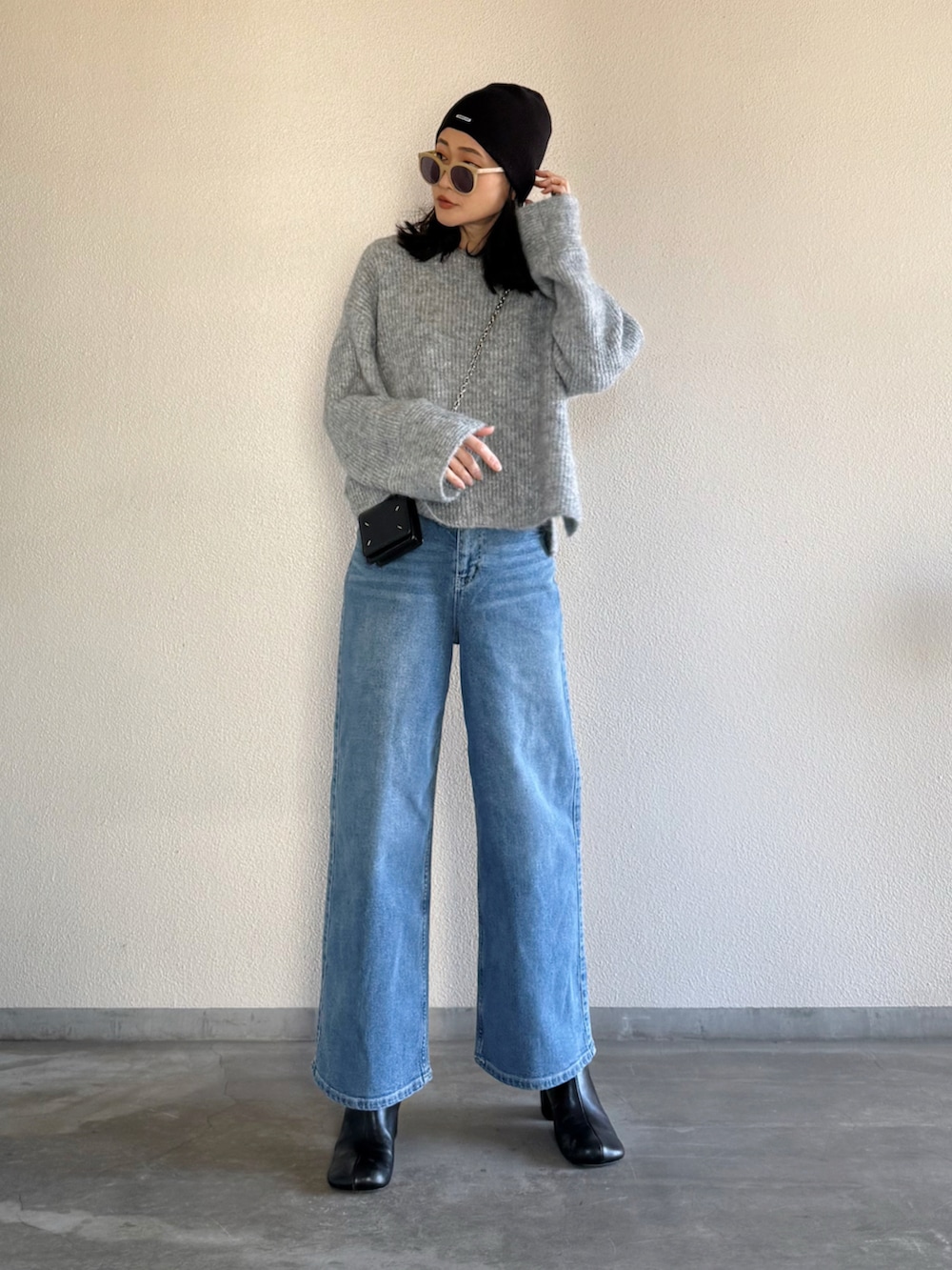 ブルー系のデニムパンツ、グレー系のニット/セーターを着用したレディースの冬コーディネートの4枚目の写真