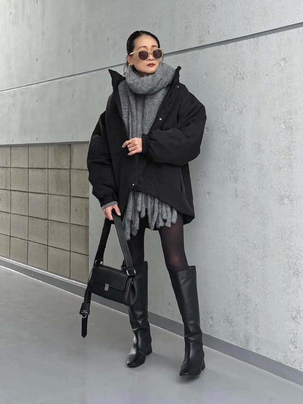 ブラック系のブルゾン、ブラック系のショルダーバッグを着用したレディースの冬コーディネートの2枚目の写真