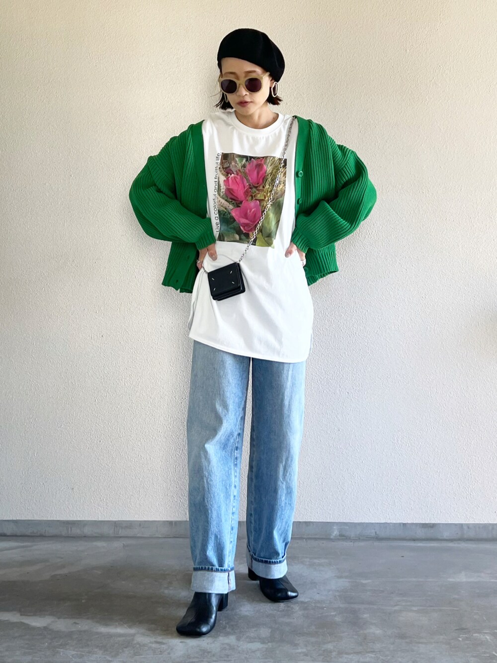 グリーン系のカーディガン/ボレロ、ホワイト系のTシャツ/カットソー、ブルー系のデニムパンツを着用したレディースの秋コーディネートの3枚目の写真
