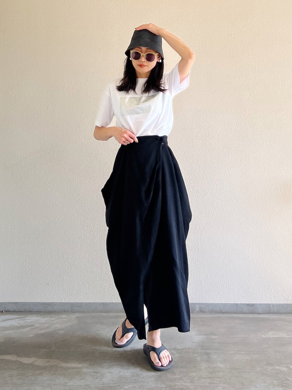 ホワイト系のTシャツ/カットソー、ブラック系のスカート、ブラック系のサンダルを着用したレディースの夏コーディネートの3枚目の写真