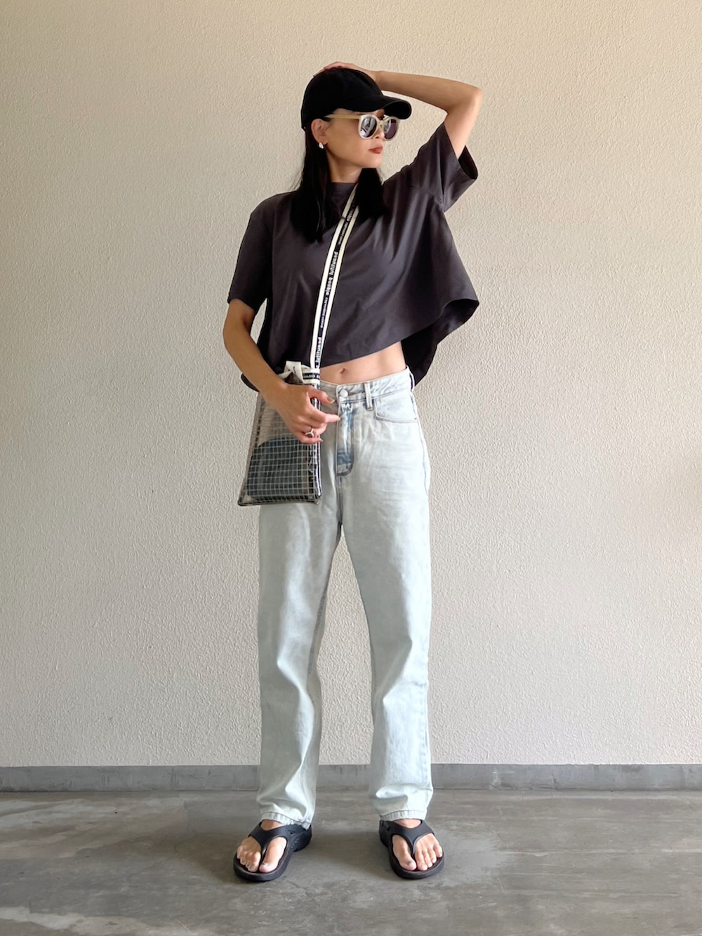 グレー系のTシャツ/カットソー、ブルー系のデニムパンツ、ブラック系のサンダルを着用したレディースの夏コーディネートの4枚目の写真