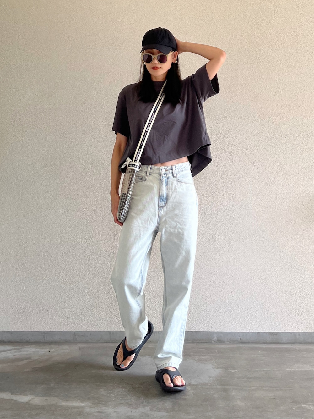 グレー系のTシャツ/カットソー、ブルー系のデニムパンツ、ブラック系のサンダルを着用したレディースの夏コーディネートの3枚目の写真