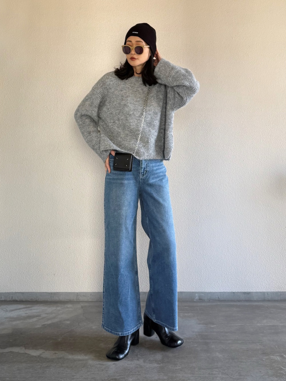 ブルー系のデニムパンツ、グレー系のニット/セーターを着用したレディースの冬コーディネートの2枚目の写真