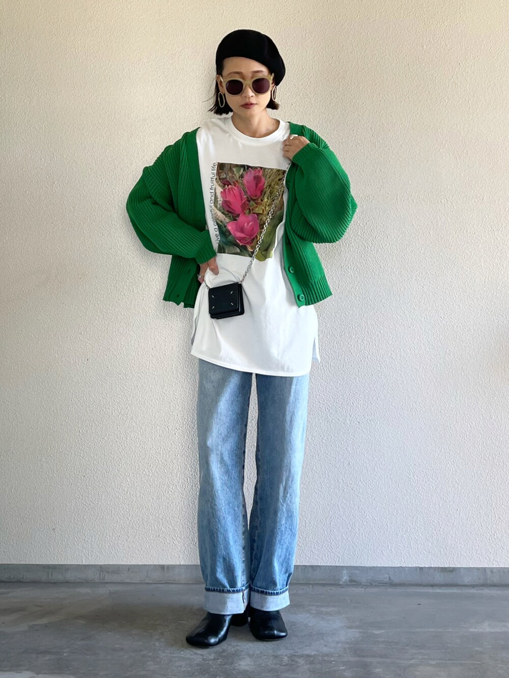 グリーン系のカーディガン/ボレロ、ホワイト系のTシャツ/カットソー、ブルー系のデニムパンツを着用したレディースの秋コーディネートの4枚目の写真