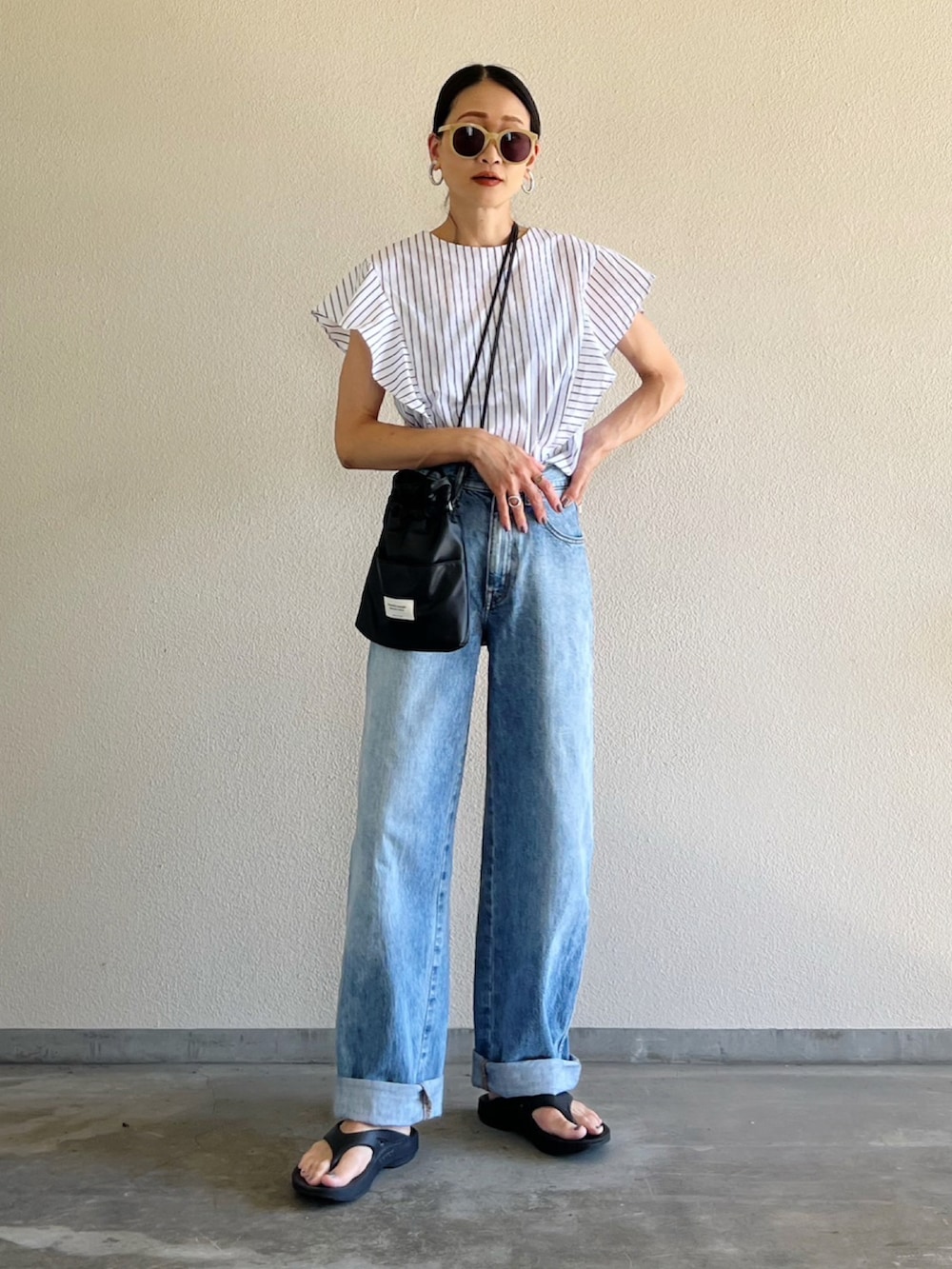 ホワイト系のシャツ/ブラウス、ブルー系のデニムパンツ、ブラック系のショルダーバッグを着用したレディースの夏コーディネートの4枚目の写真