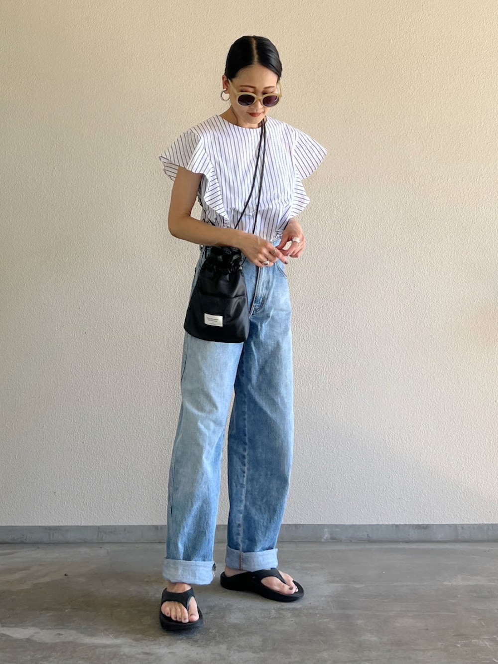 ホワイト系のシャツ/ブラウス、ブルー系のデニムパンツ、ブラック系のショルダーバッグを着用したレディースの夏コーディネートの2枚目の写真