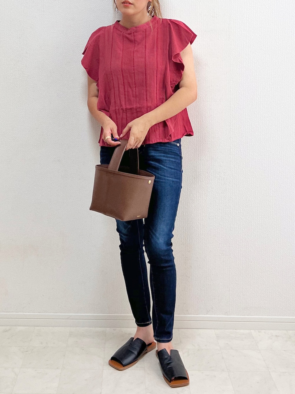 ピンク系のシャツ/ブラウス、ブルー系のデニムパンツ、ブラウン系のバッグを着用したレディースの夏コーディネートの4枚目の写真