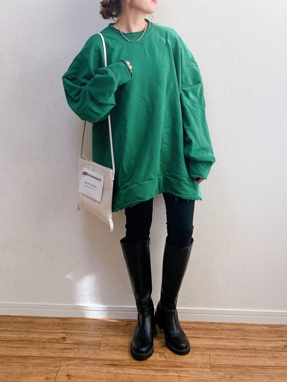 グリーン系のスウェット、ブラック系のその他パンツ、ブラック系のブーツを着用したレディースの冬コーディネートの2枚目の写真