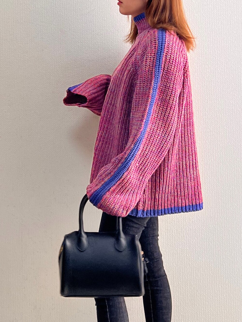 ピンク系のニット/セーター、ブラック系のブーツを着用したレディースの秋コーディネートの3枚目の写真