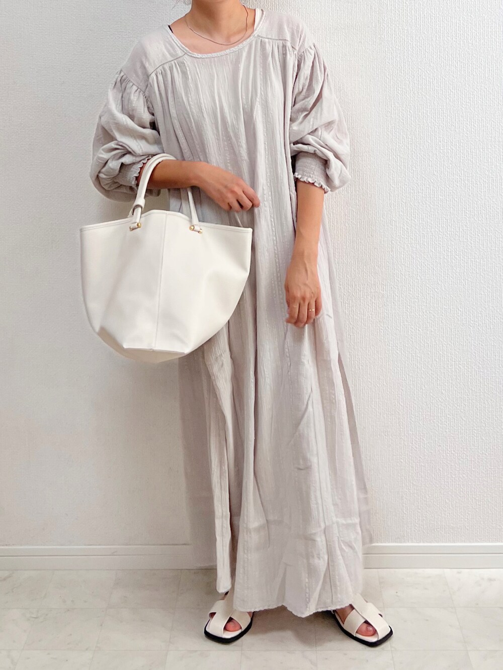 グレー系のワンピース、シルバー系のネックレスを着用したレディースの夏コーディネートの2枚目の写真