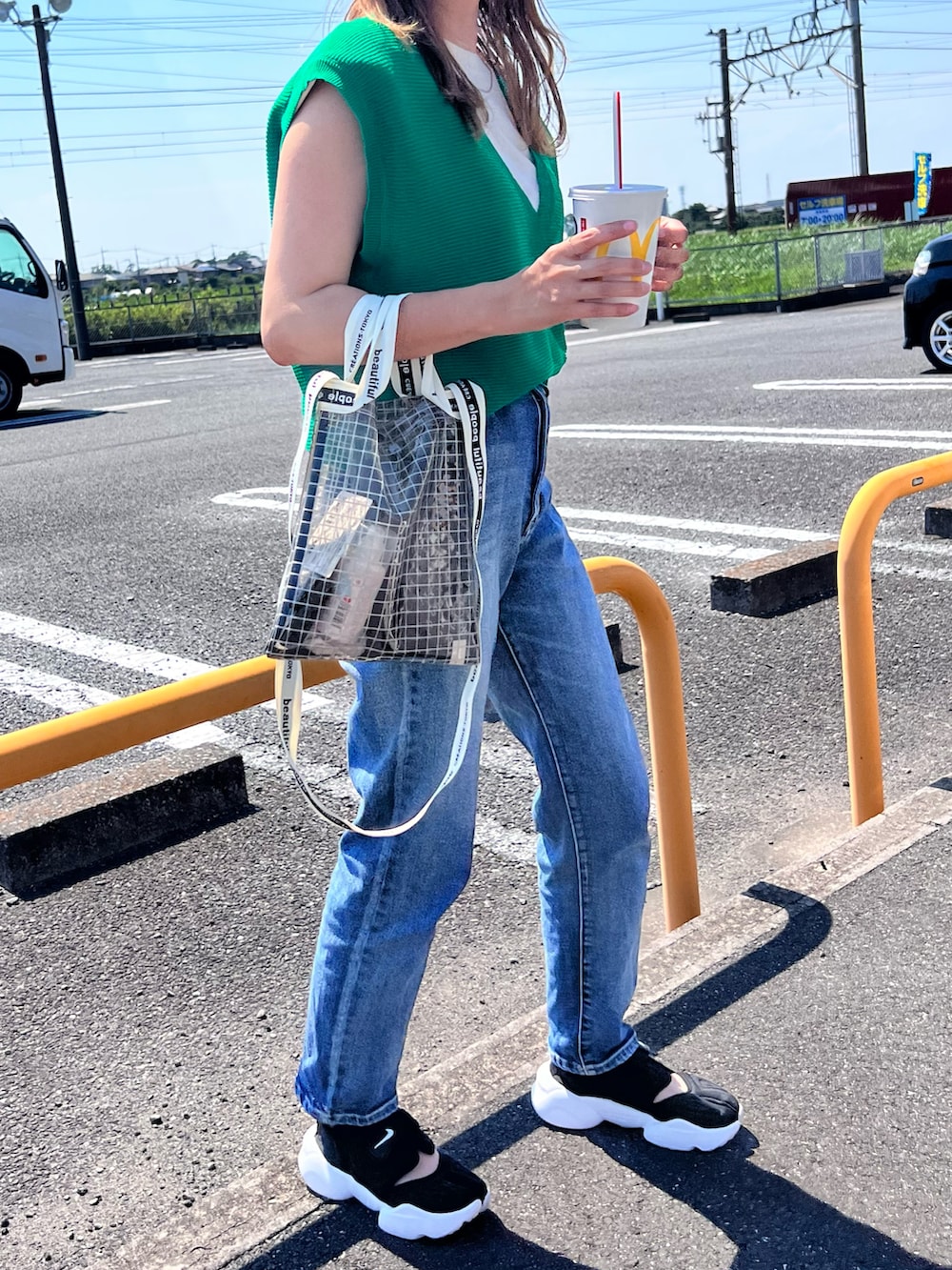 グリーン系のベスト、ベージュ系のTシャツ/カットソー、ブラック系のショルダーバッグを着用したレディースの夏コーディネートの3枚目の写真